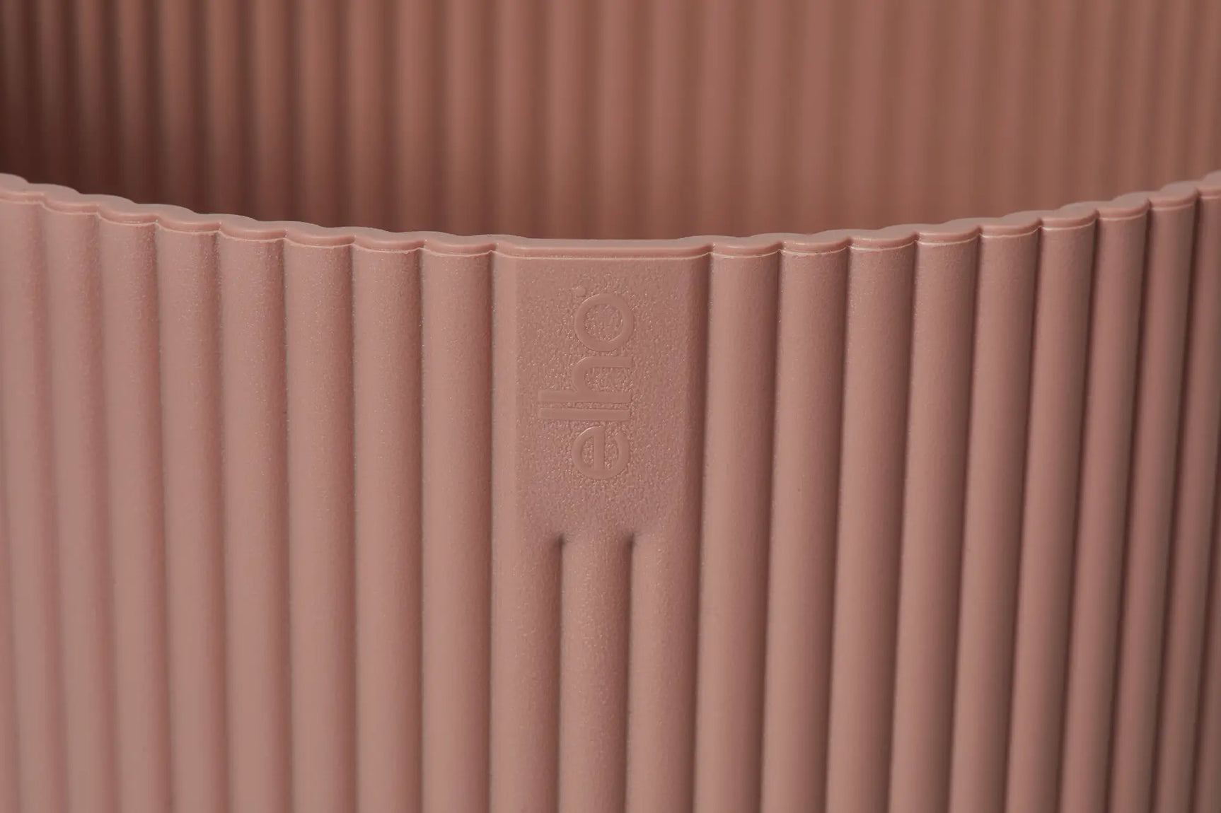 Ronde plantenbak delicate roze met reliëf op de wand