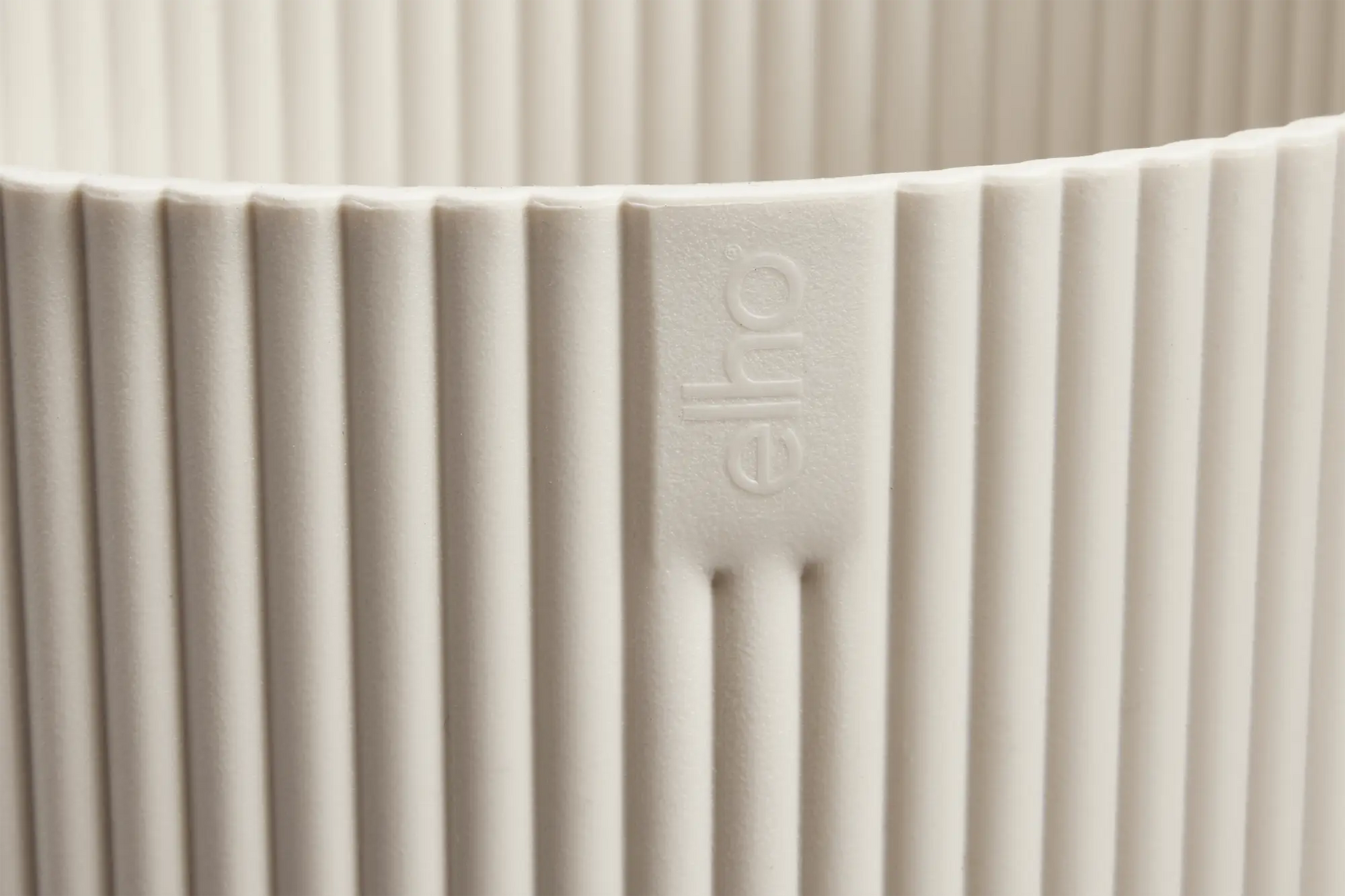 Elho mini bloempot, close-up geribde linnen-witte wand met logo