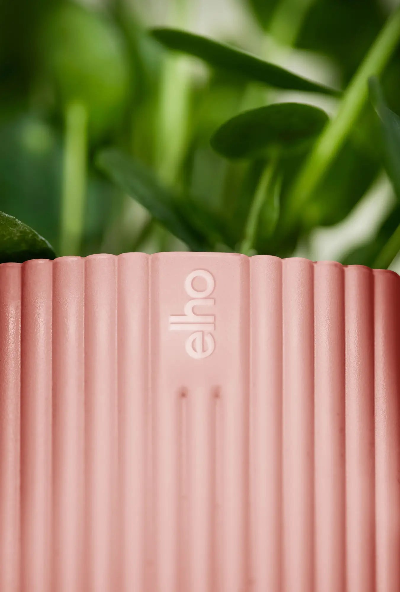 Roze plantenpot met verticale ribbels en elho-logo in reliëf op de zijkant