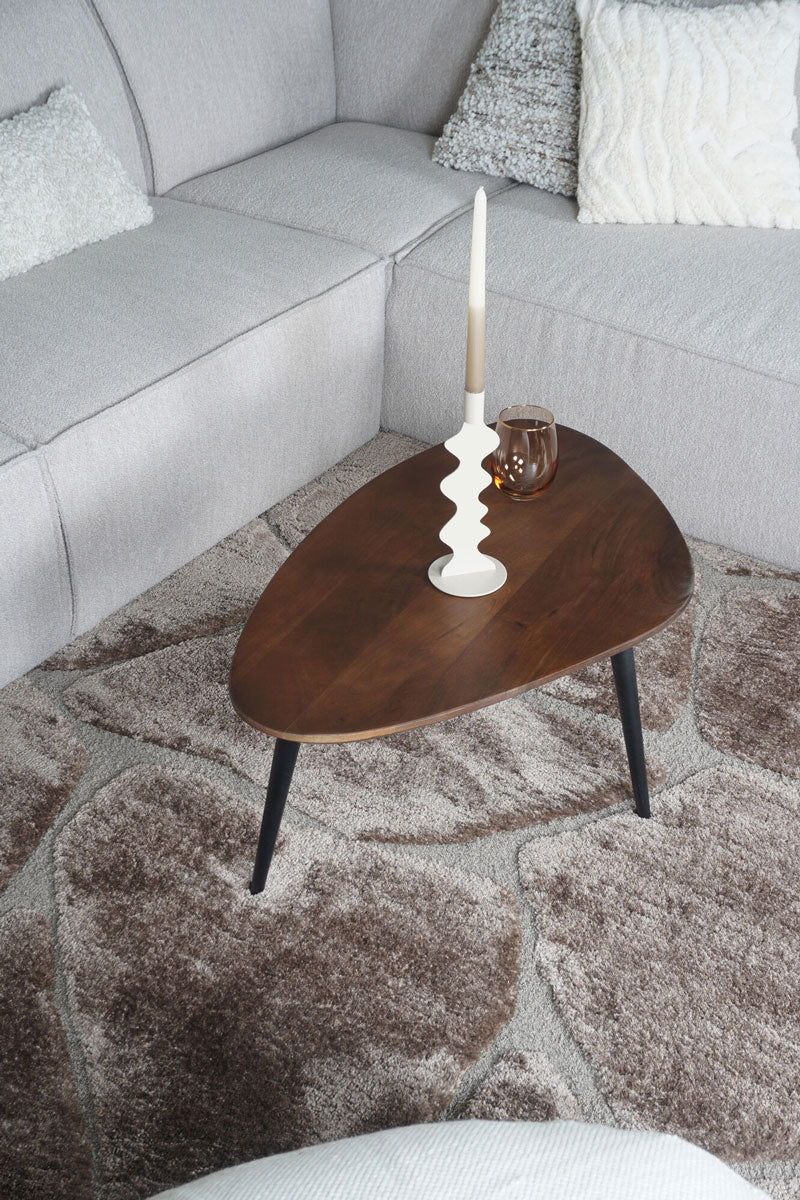 Bruin vloerkleed met abstract patroon, gedeeltelijk zichtbaar onder tafel