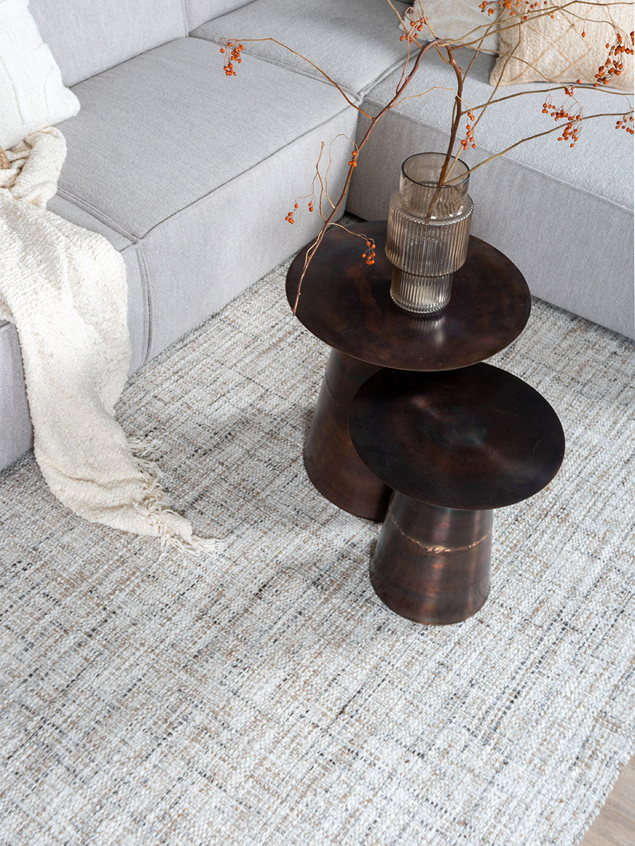 Vloerkleed lichtbeige met gemêleerde vezels en subtiele weving; zichtbare rand