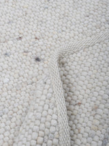 Ronde karpet met lichte grijstint, noppige bouclé-textuur en smalle rand