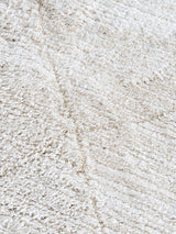 Crème vloerkleed close-up met grove, getextureerde pool en subtiele lijnen