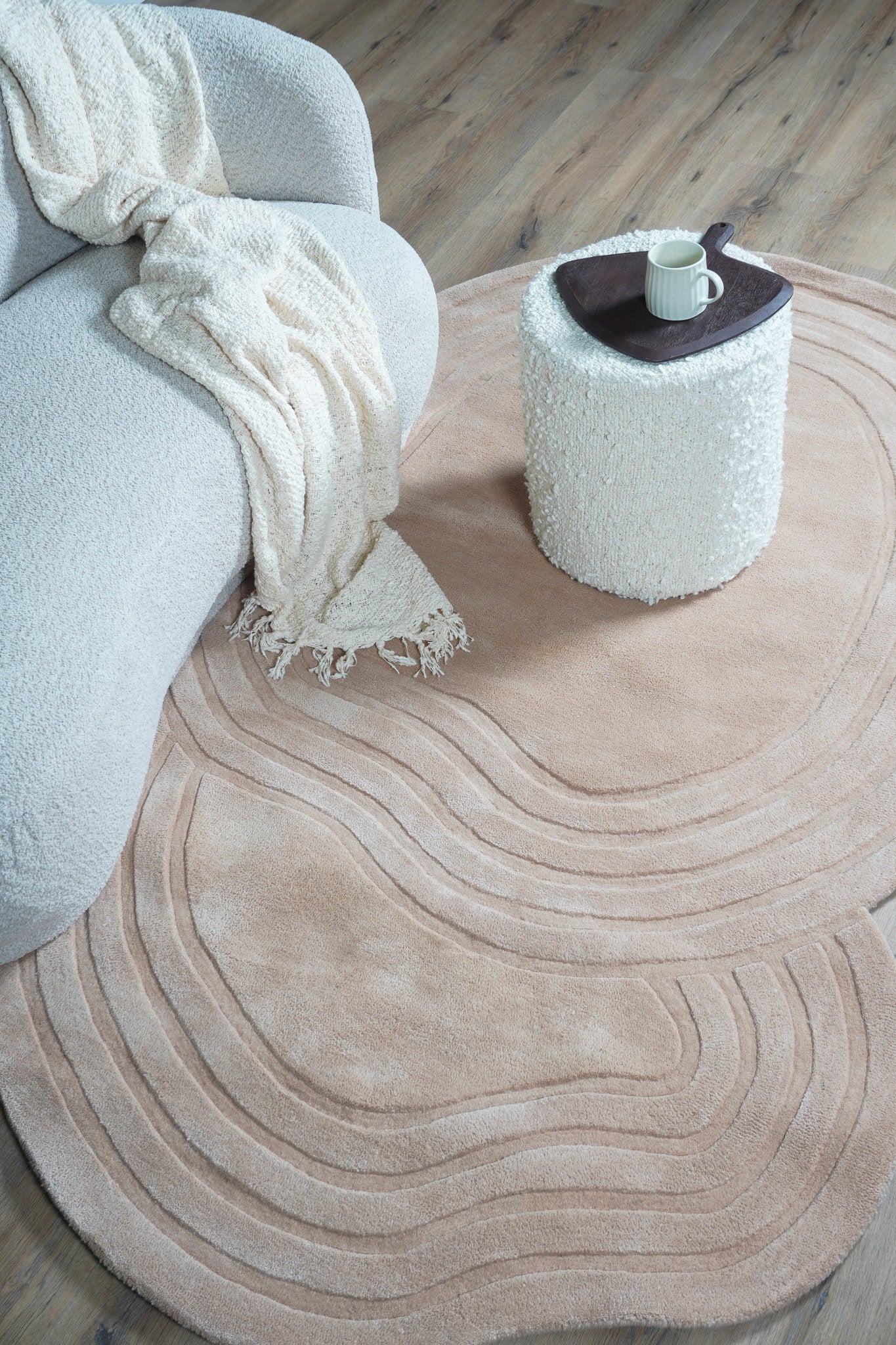 Beige vloerkleed met golvende ovale patroonlijnen en gestreepte randen